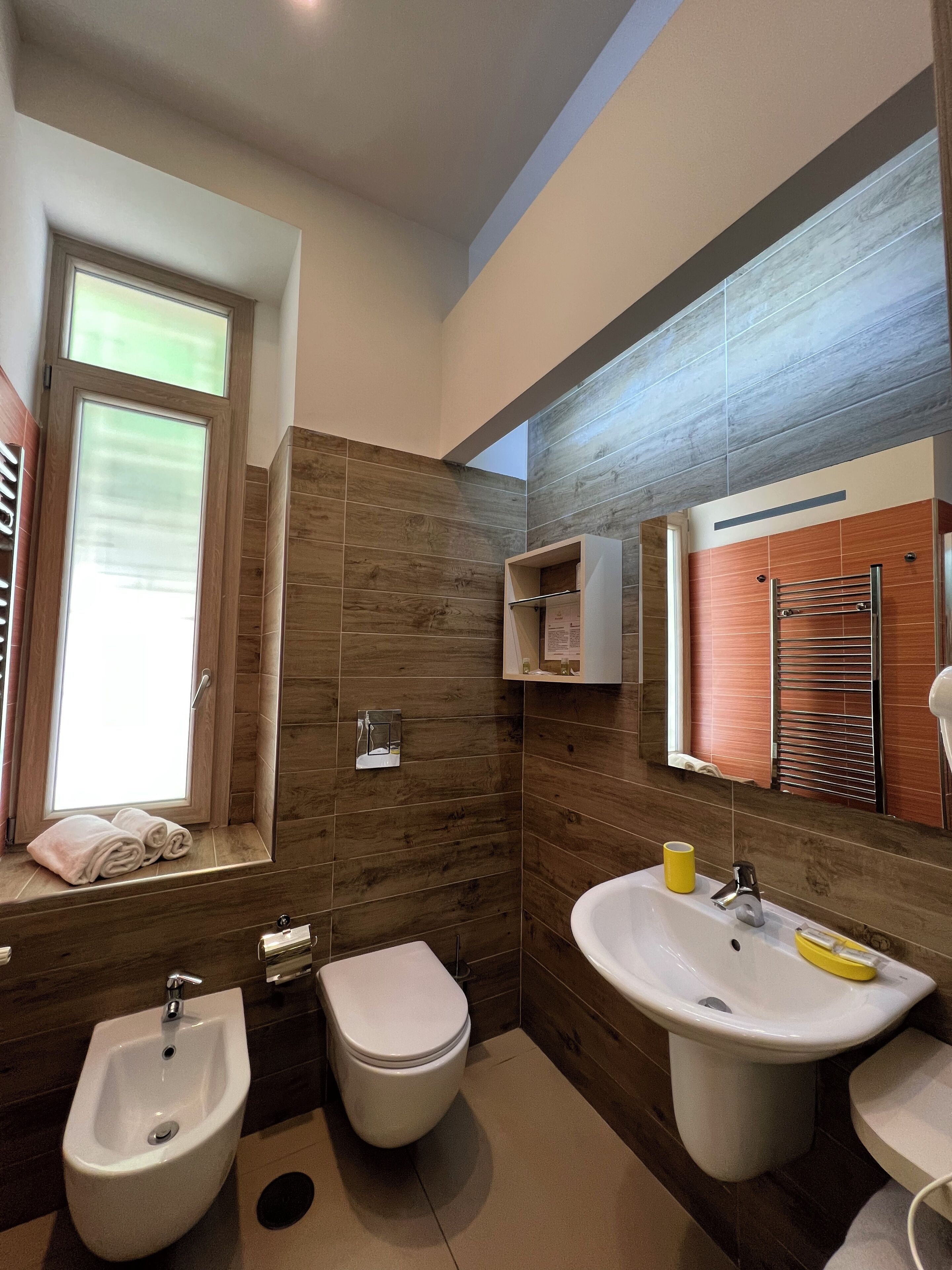 A modern bathroom with a bidet, toilet, and sink.