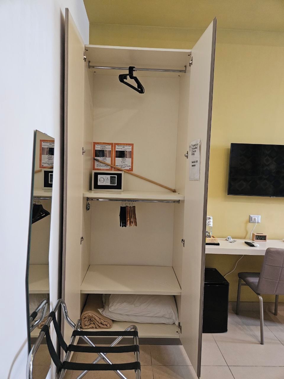 A compact room with a bunk bed, a desk, a chair, and a television.