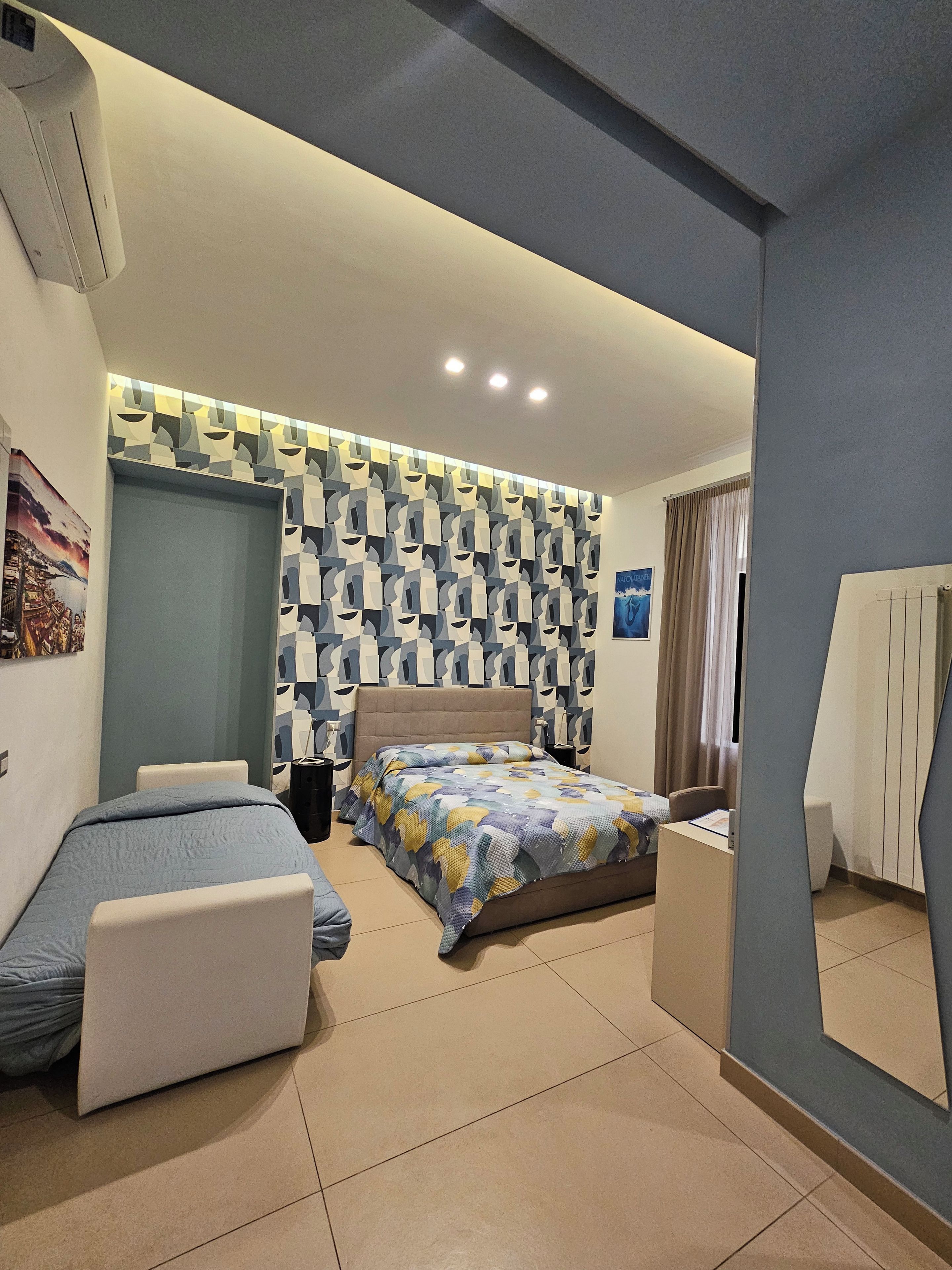 Una habitación de hotel con una cama, un sofá, un escritorio y un espejo.