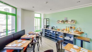 A dining area with tables, chairs, and a buffet counter. - Hôtel du Champ de Mars (Saint-Brieuc)