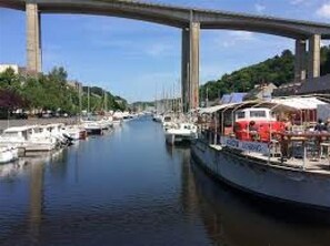 Ein Fluss mit Booten und einer Brücke im Hintergrund.