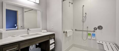 A modern bathroom with a double sink vanity, a glass shower enclosure, and a walk-in shower.