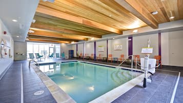 Una piscina techada, sillones reclinables de piscina