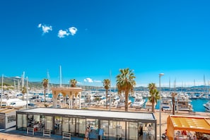 Ein Yachthafen mit Booten, Palmen und einem Restaurant mit Glasdach.