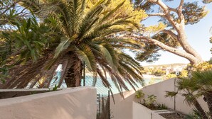 A staircase leading to a pool area with palm trees and a view of buildings in the background.