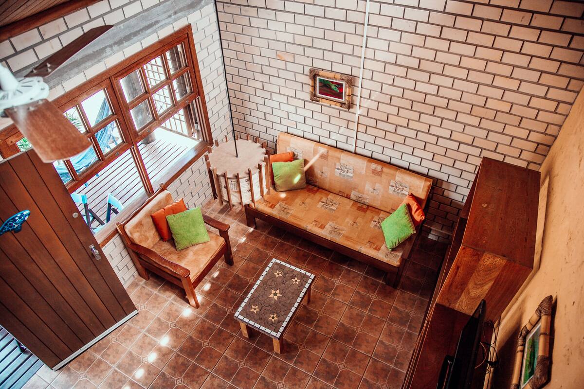 A cozy living area with a brick wall, wooden furniture, and a tiled floor.