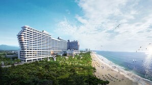 Een groot hotel met meerdere verdiepingen, een ligging aan het strand en uitzicht op de oceaan.