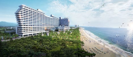 A large hotel with multiple floors, a beachside location, and a view of the ocean.