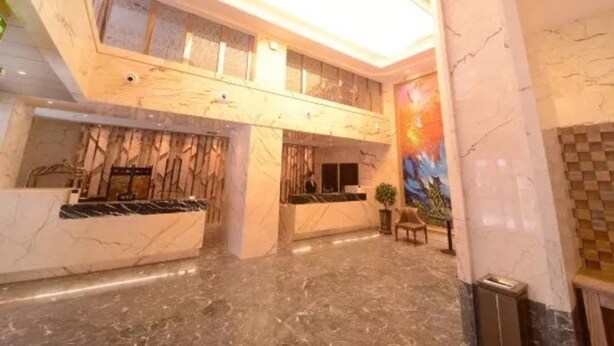 A spacious lobby with marble floors, a reception desk, and a large window. - Harbin Yuxuan Hotel (Harbin)