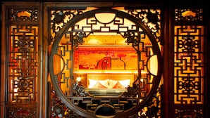 A traditional Chinese room with intricate wooden carvings and a circular window. - Lijiang Golden Path Hospitality (Lijiang)