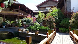 A traditional wooden building with a wooden deck and a small water feature. - Lijiang Golden Path Hospitality (Lijiang)