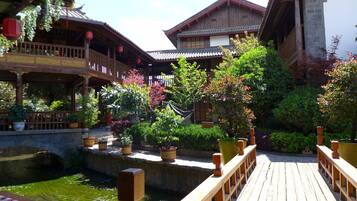 A traditional wooden building with a wooden deck and a small water feature.