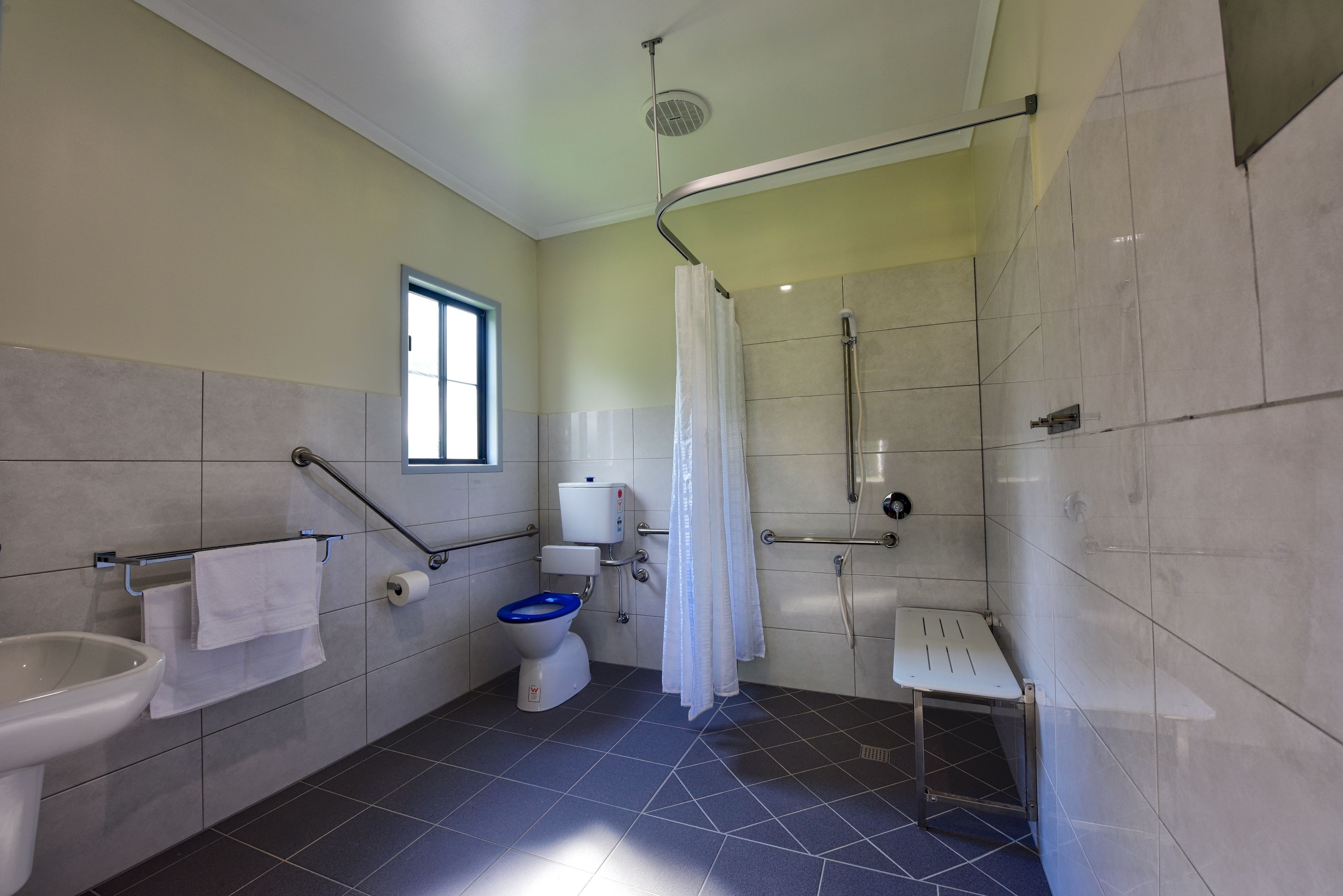 Un baño con inodoro, bidé, lavamanos y zona de ducha.