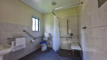 Un baño con inodoro, bidé, lavamanos y zona de ducha.