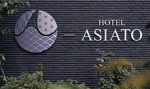 A hotel sign with a stylized logo and the name 'HOTEL ASIATO' on a textured wall. - Hotel ASIATO Namba (Osaka)