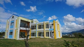 A multi-story building with a flat roof, large windows, and a balcony. - Kuan Min Home (Hengchun)