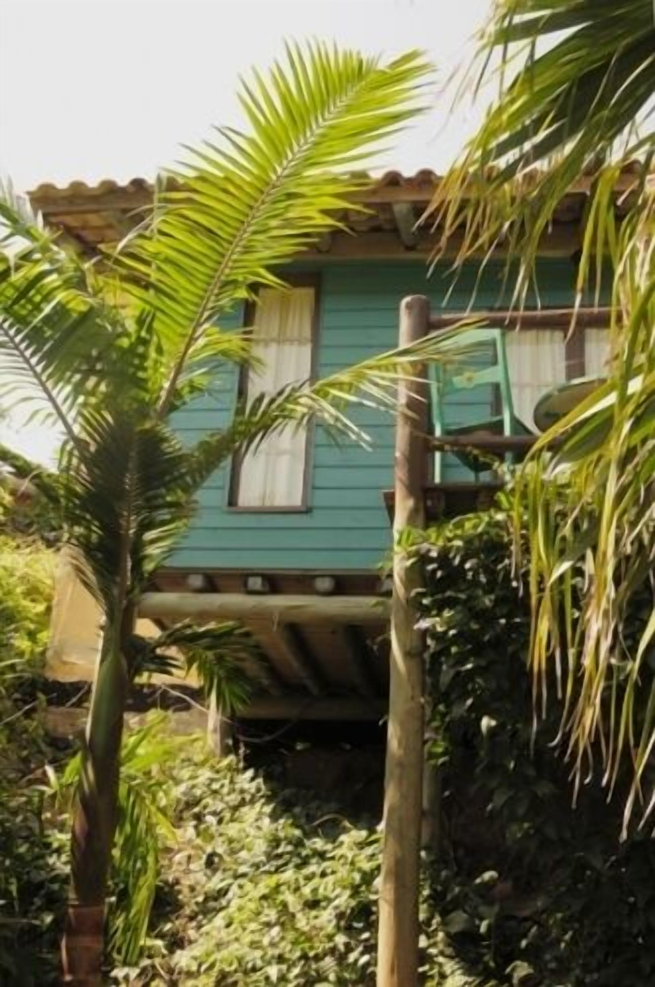 A house with a green exterior and a porch.