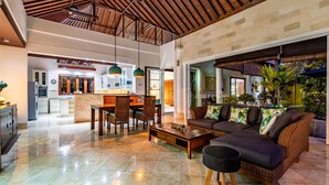 A spacious living area with a high ceiling, a dining area, and a kitchen. - Villa Livo (Denpasar)