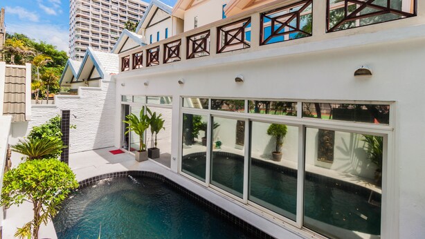 Un hôtel moderne doté d’une piscine, de grandes fenêtres et offrant une vue sur les bâtiments environnants.