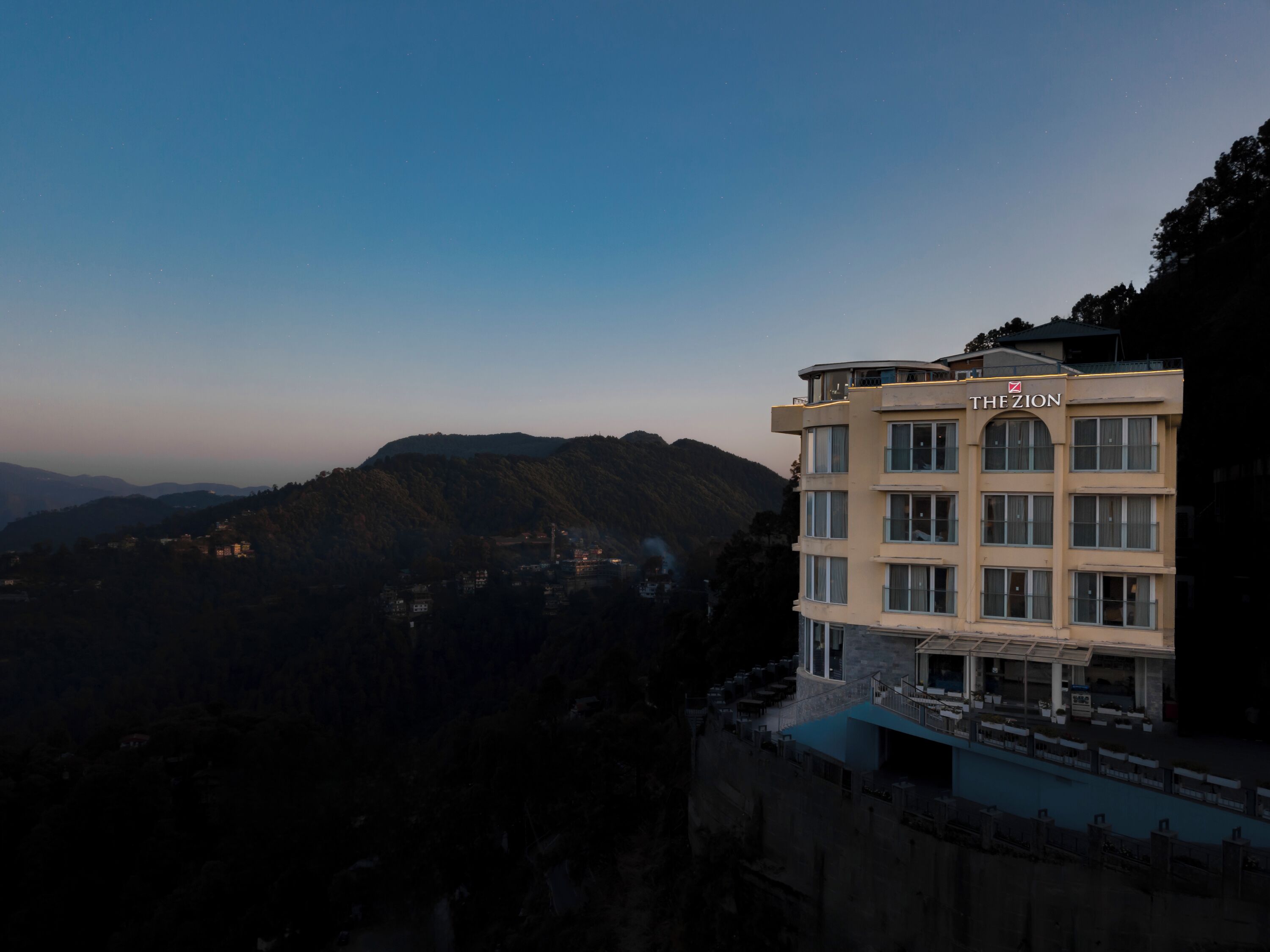 Un hotel llamado "The Zion" con vistas a montañas al fondo.