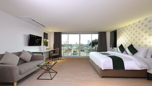 Quarto de hotel moderno com cama, sofá e escrivaninha.