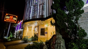 Un bâtiment moderne avec une enseigne au néon indiquant qu’il s’agit d’un motel.