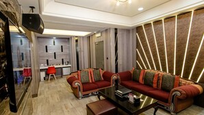 Un salon moderne avec un ensemble de canapés, une table basse et un fauteuil rouge.