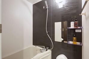 Un baño moderno con ducha, inodoro y tocador con espejo.