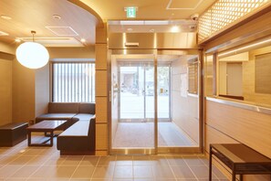 A modern lobby with a seating area, a reception desk, and a glass door entrance. - Hotel Amaterrace Yosuga (Osaka)