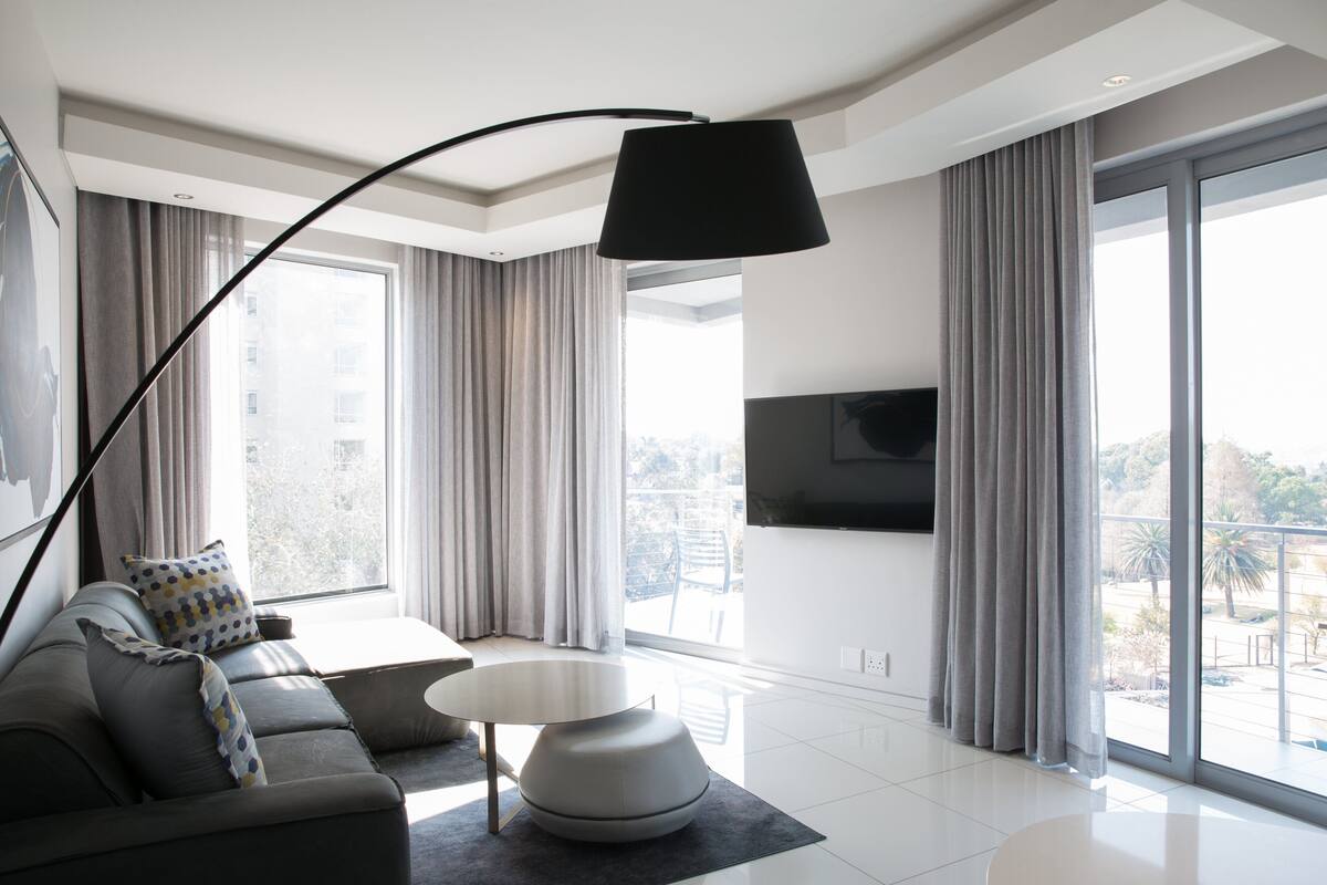 Una sala de estar moderna con un sofá, una mesa de centro y un televisor de pantalla plana montado en la pared.