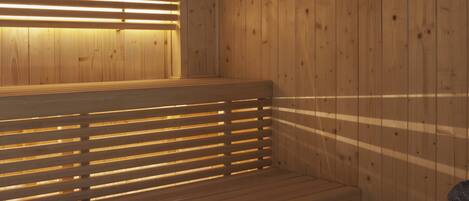 A wooden sauna with slatted benches and a bench in the foreground.