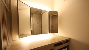 Casa de banho com espelho, lavatório e suporte para toalhas.