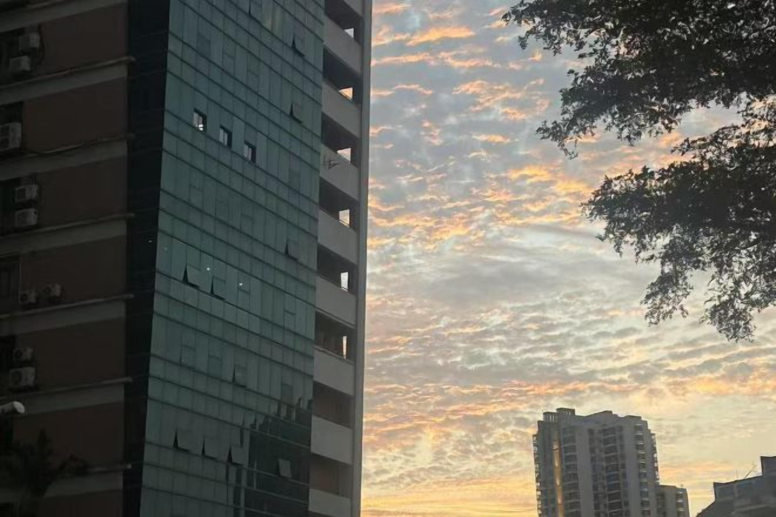 A high-rise building with a clear sky and a sunset.