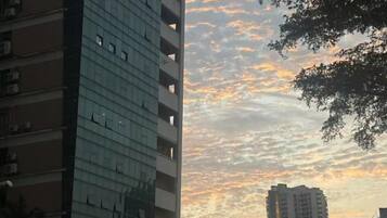 A high-rise building with a clear sky and a sunset.