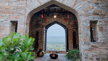 An arched stone doorway leading to a view of a valley.