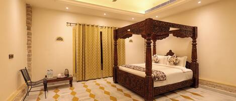 A four-poster bed with a wooden frame, a ceiling fan, and a checkered floor pattern.