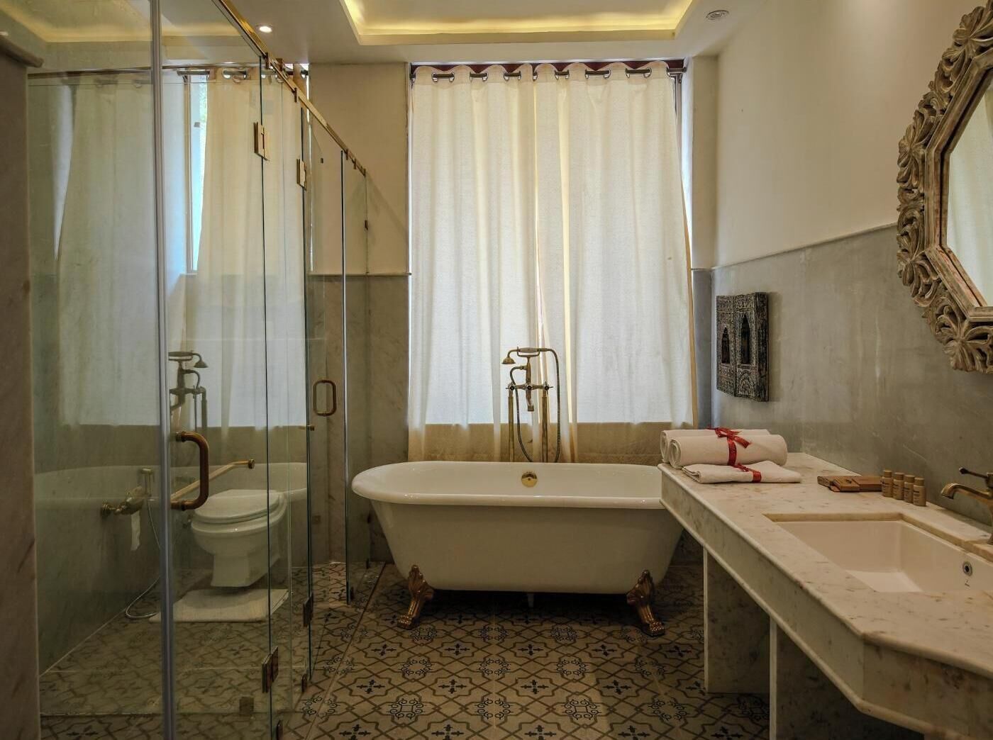 A bathroom with a glass-enclosed shower, a freestanding bathtub, and a large mirror.