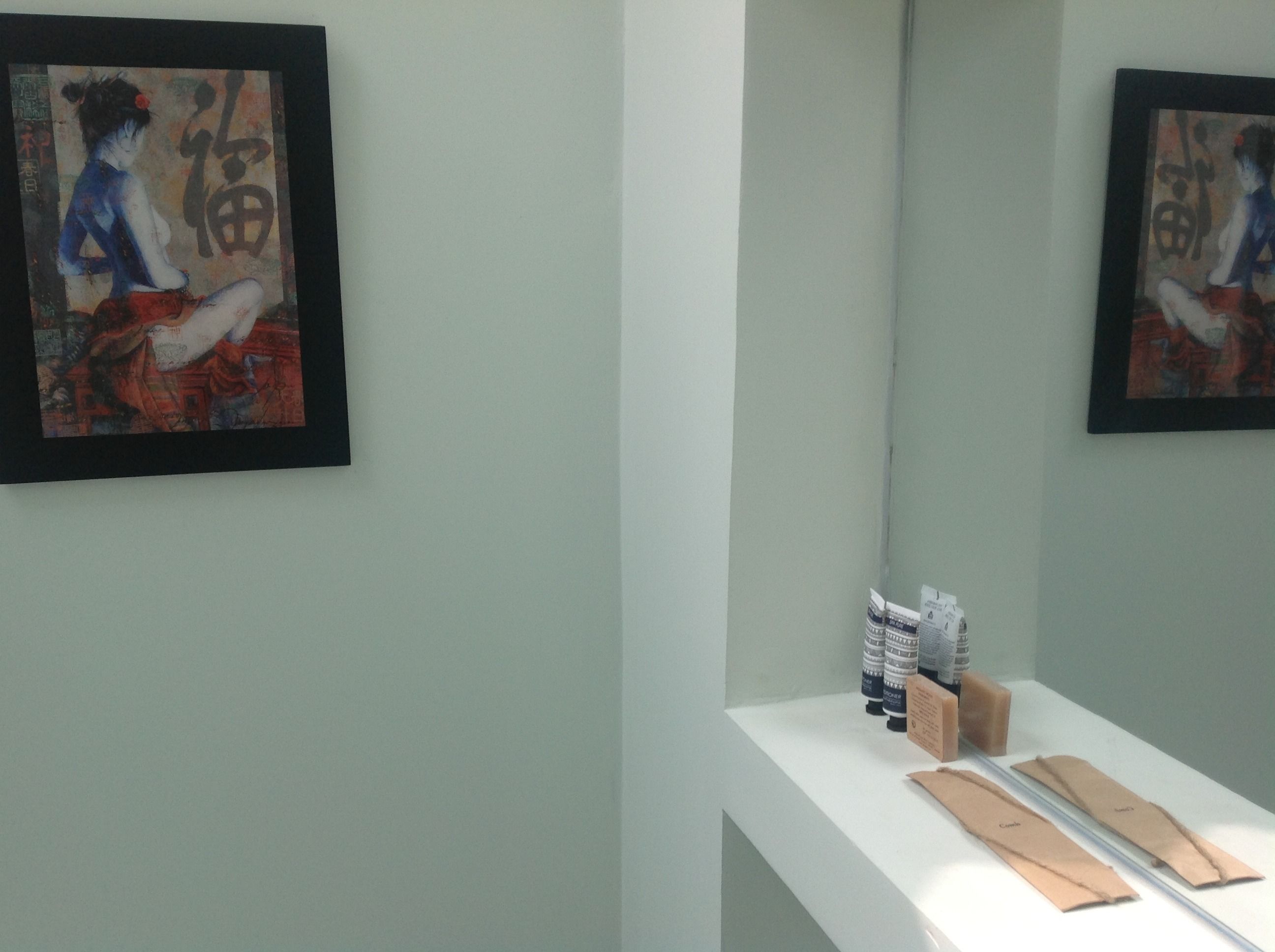 Una galería con obras de arte enmarcadas en las paredes y una mesa que exhibe varios objetos.