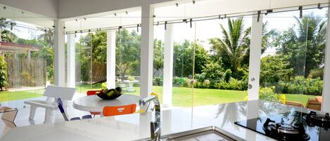 A modern kitchen with a large window, a sink, and a gas stove.