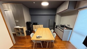 A compact kitchen with a refrigerator, microwave, and stove. - Kokusai Towns Inn (Naha)