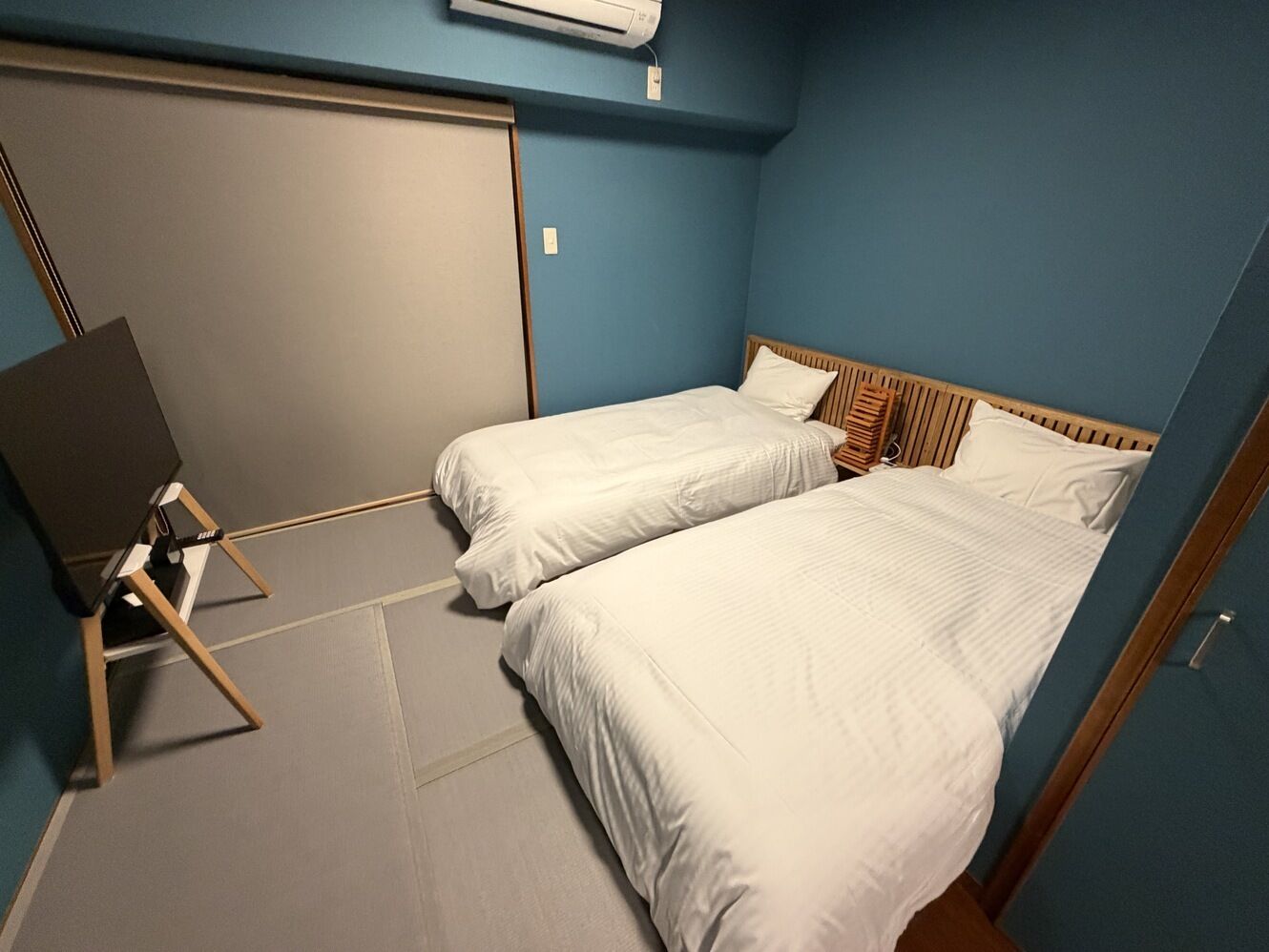 Une chambre avec deux lits, un bureau et une armoire.