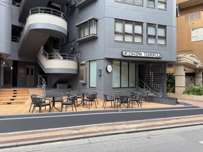A modern building with a sign reading 'UKISHIMA TERRACE' and a sign indicating laundry services. - Kokusai Towns Inn (Naha)