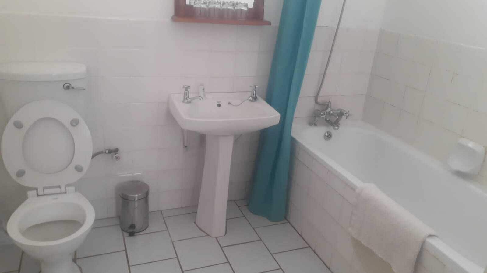 A bathroom with a toilet, sink, and bathtub.