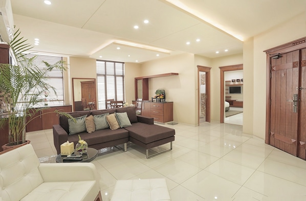 Suite Deluxe | Área de sala de estar | Televisión de pantalla plana y chimenea