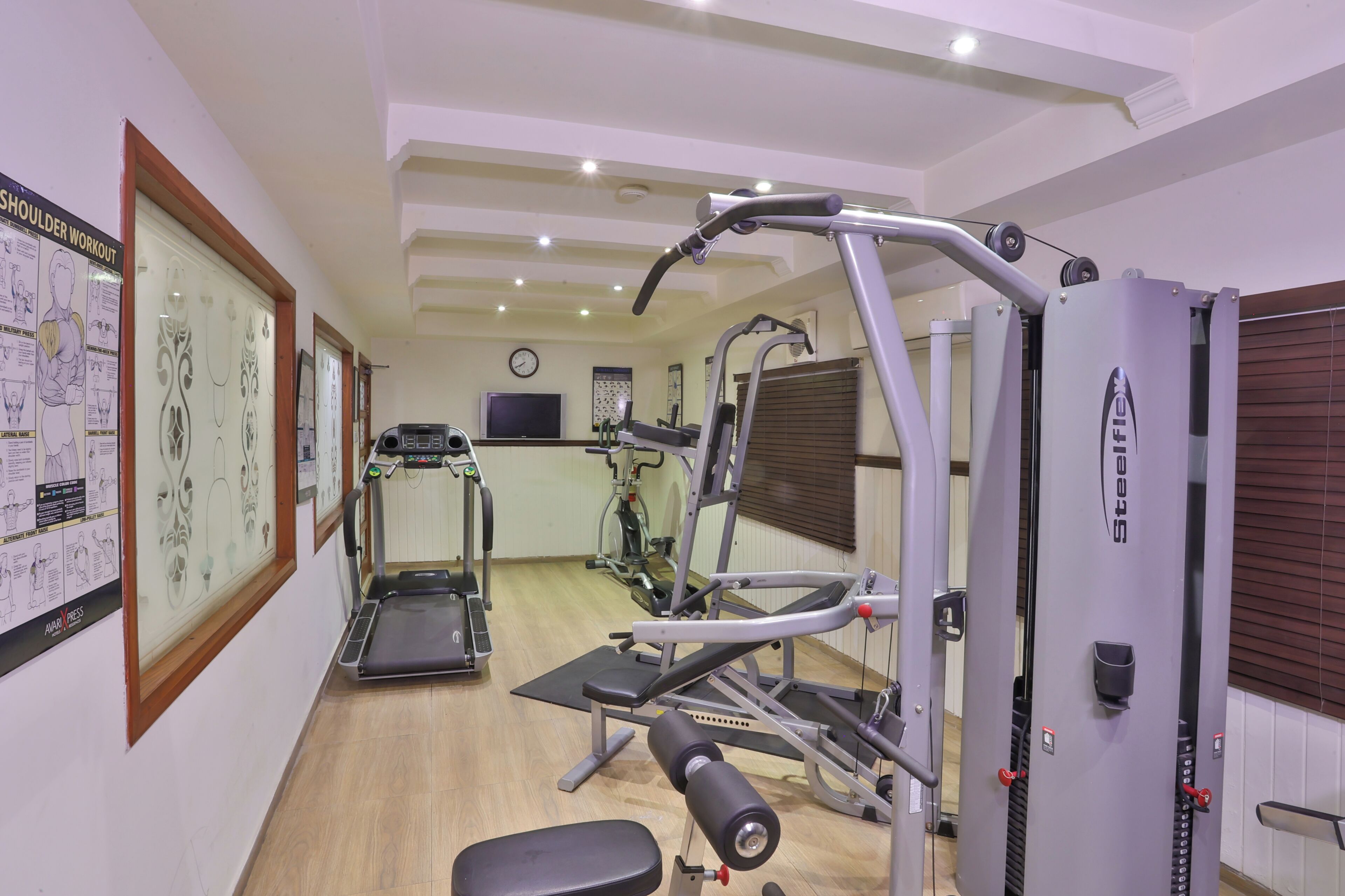 Een sportschool met loopbanden, krachttrainingsapparatuur en fitnessapparaten.