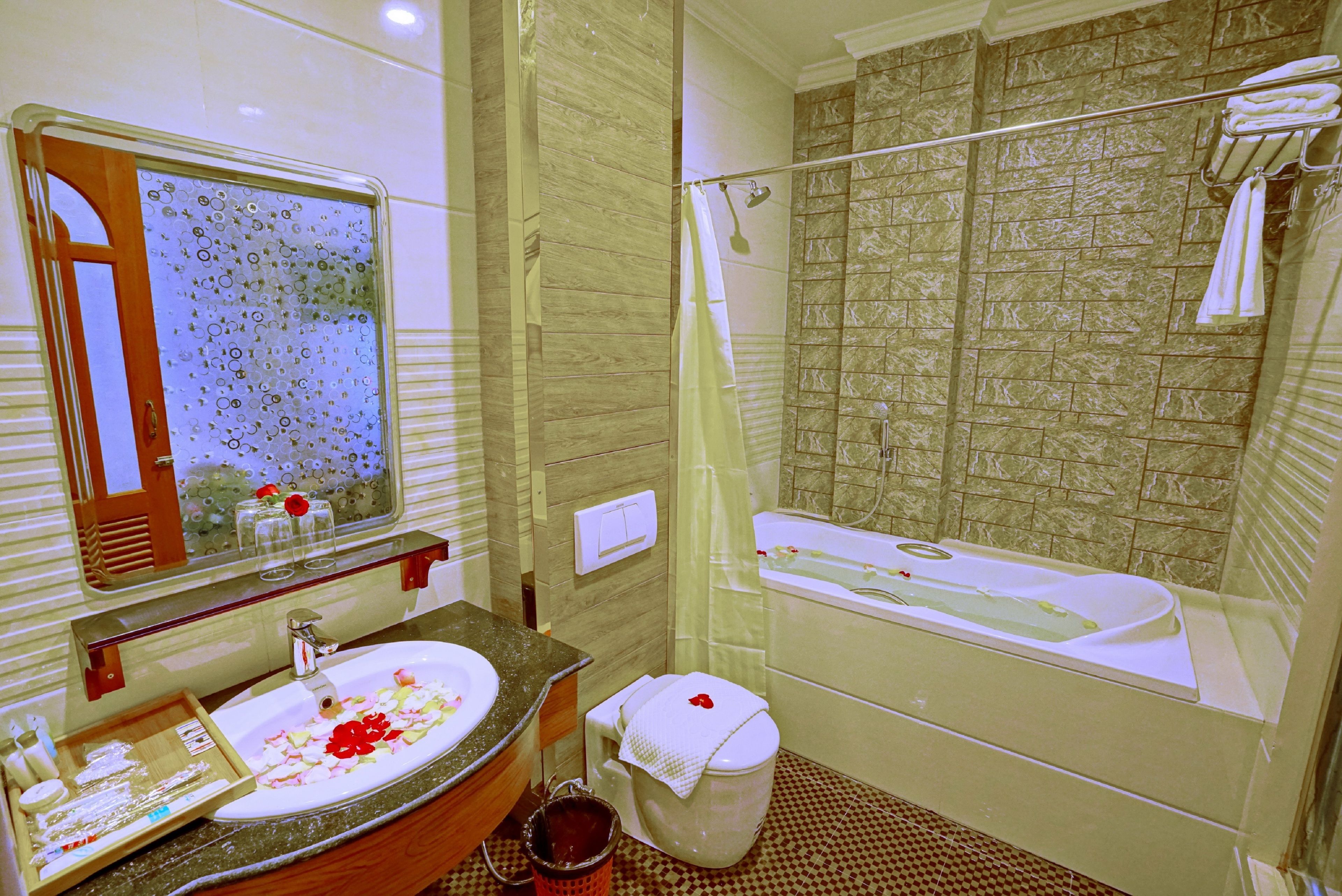 A bathroom with a sink, mirror, toilet, and bathtub.