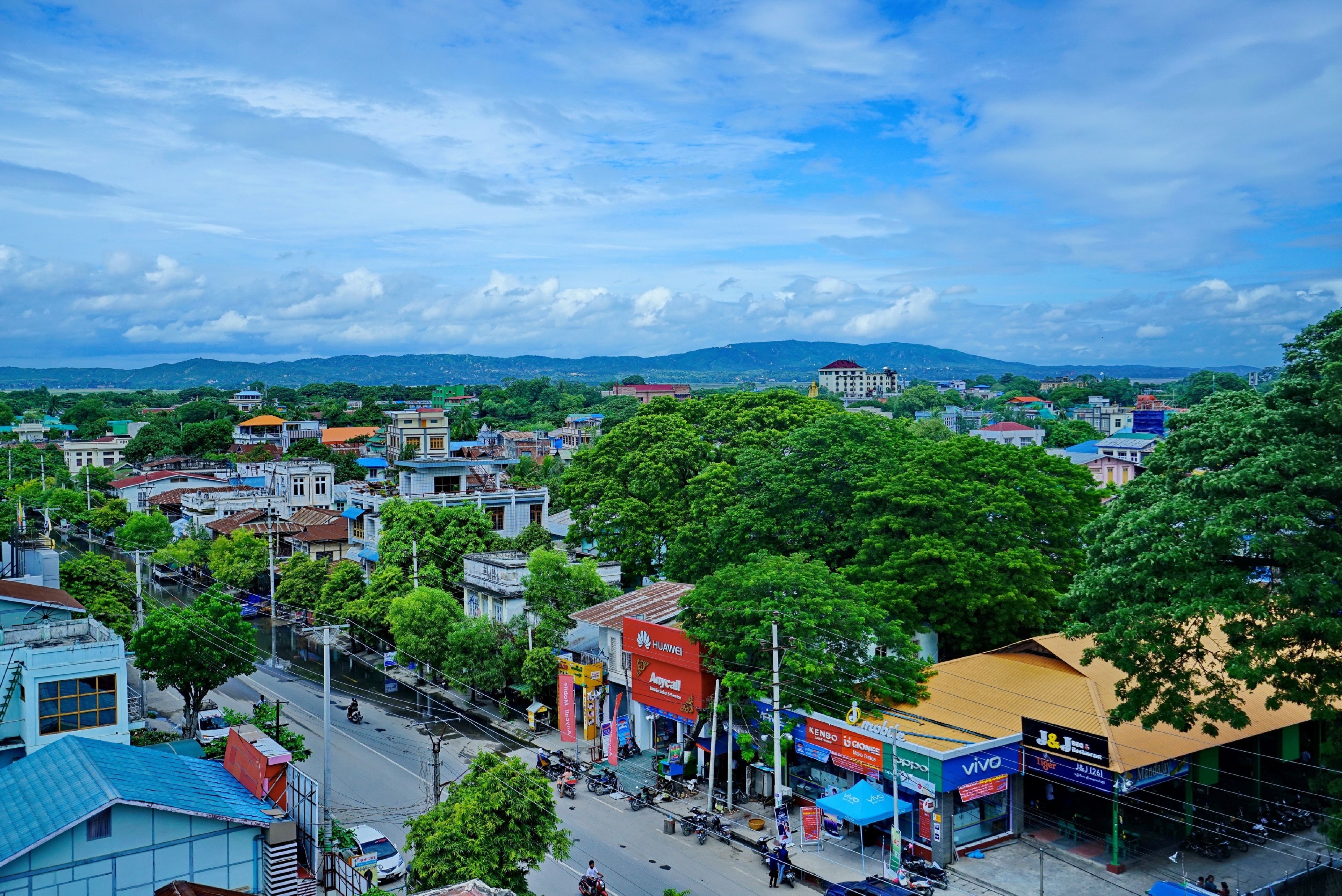 A cityscape with various buildings, including a prominent red and white sign for a telecom company.
