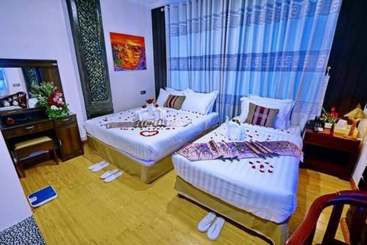 Una habitación de hotel con dos camas, un escritorio y una silla.