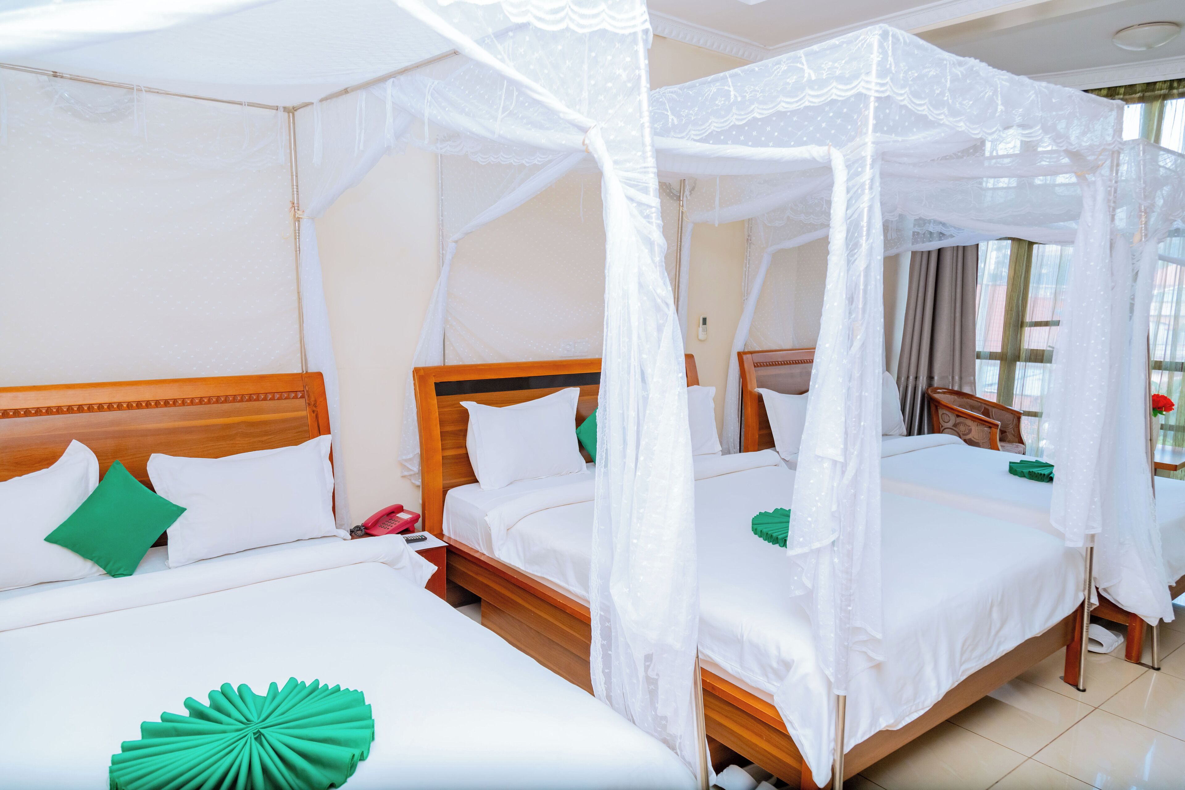 Une chambre d’hôtel avec deux lits, chacun doté d’une tête de lit en bois et de linge de lit blanc.