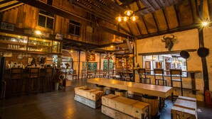 A rustic interior with wooden beams, a bar area, and seating arrangements. - 60s Town (Hua Hin)